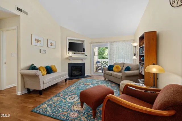 a living room with furniture a fireplace and a flat screen tv
