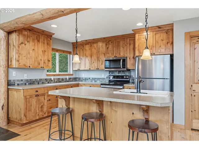 a kitchen with stainless steel appliances granite countertop a sink refrigerator and microwave