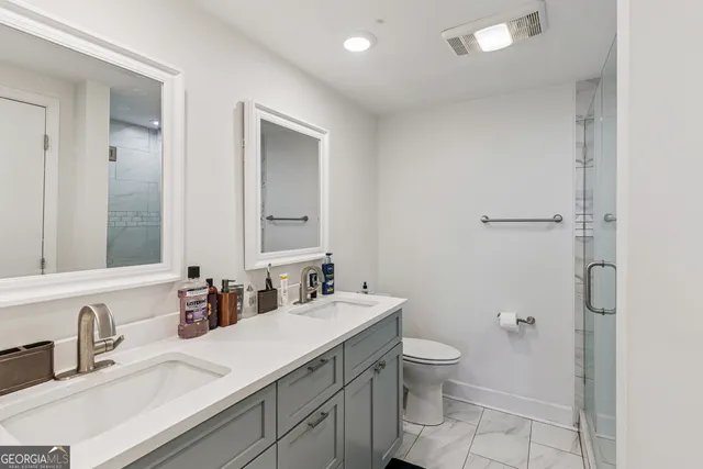 a bathroom with a granite countertop sink a toilet and a mirror