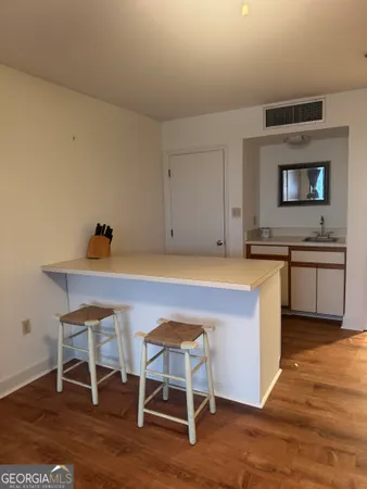 a kitchen with granite countertop chair and wooden floor