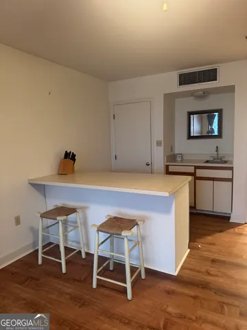 a kitchen with granite countertop chair and wooden floor