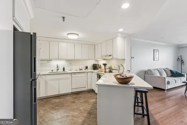a kitchen with sink refrigerator and cabinets