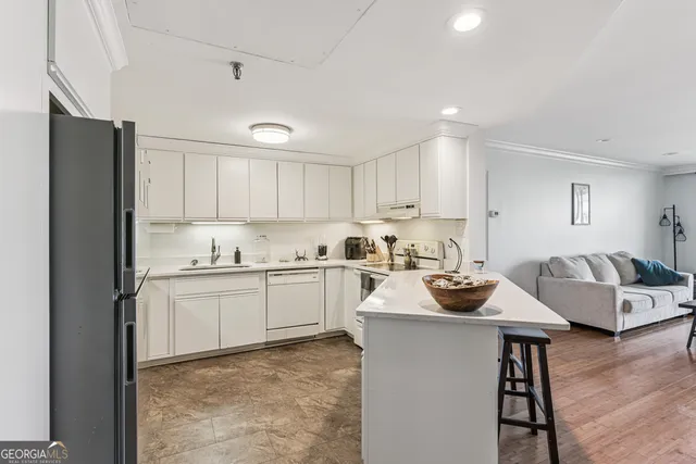 a kitchen with sink refrigerator and cabinets