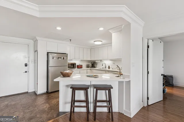 a kitchen with refrigerator and white cabinets