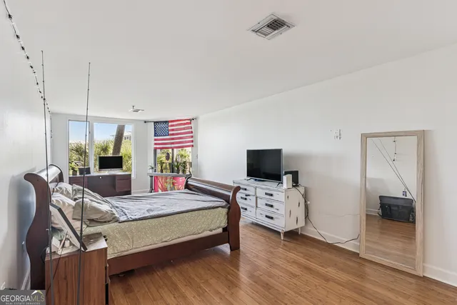 a bedroom with a bed and wooden floor