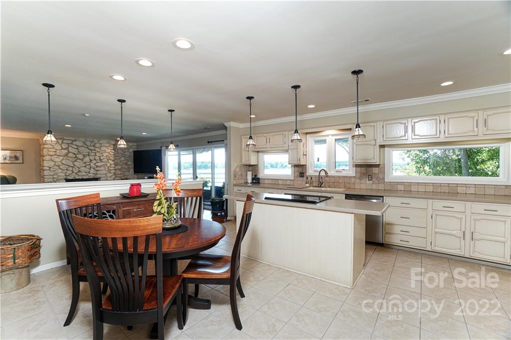 8032 Windjammer Drive Tega Cay, SC 29708 - Photo 12 of 48 a kitchen with a dining table chairs and white cabinets