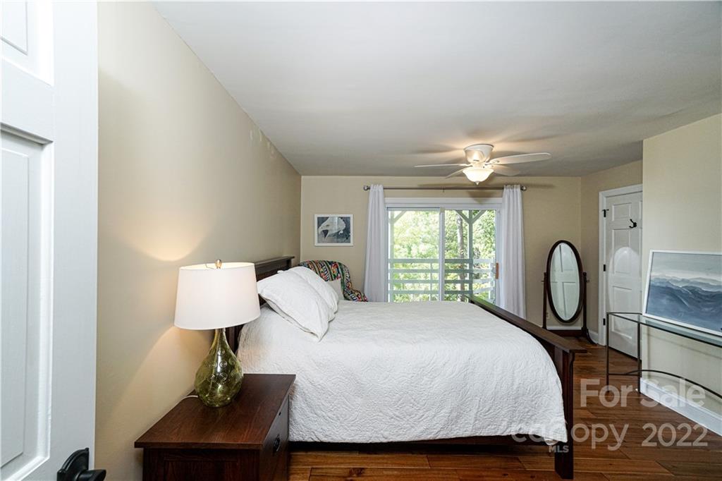 8032 Windjammer Drive Tega Cay, SC 29708 - Photo 31 of 48 a bed sitting in a bedroom next to a window with lamp