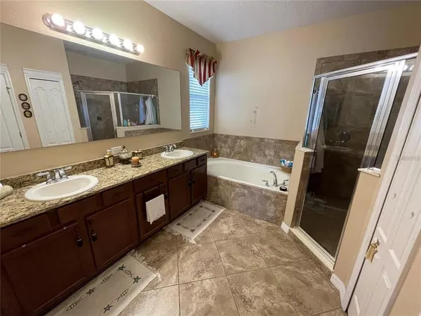 a bathroom with a granite countertop double vanity and a mirror