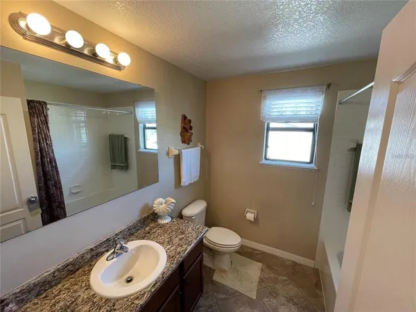 a bathroom with a sink mirror and toilet