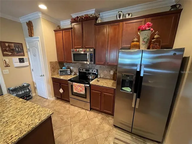 a kitchen with stainless steel appliances granite countertop a refrigerator and a stove
