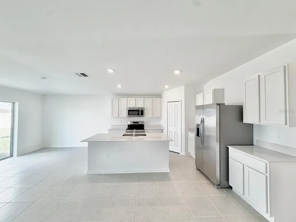 a kitchen that has a sink a stove top oven a counter space and cabinets