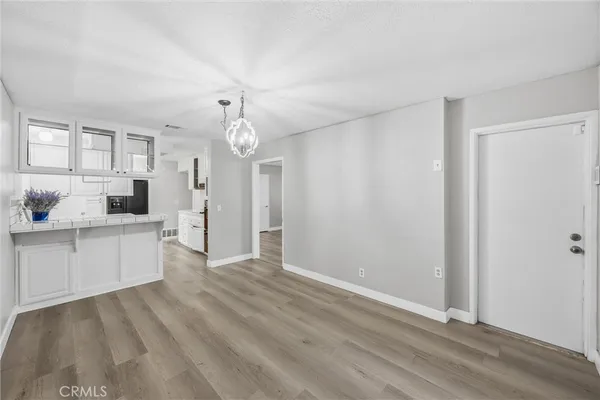 an empty room with wooden floor and ceiling fan
