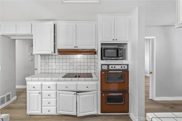 a view of a big room with wooden floor and a chandelier fan