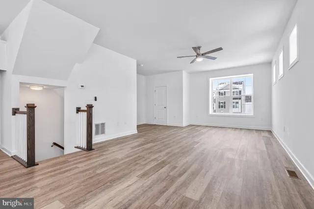 a large kitchen with a wooden floor and stainless steel appliances
