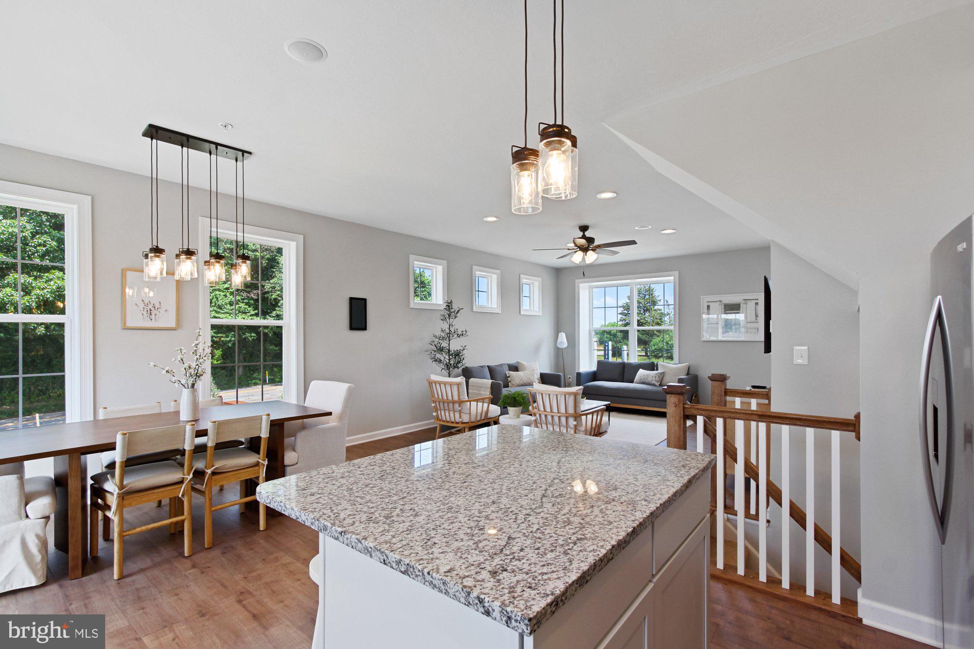 436 Bradford Drive, Unit 59 Red Lion, PA 17356 - Photo 7 of 43 a view of a dining room and livingroom with furniture wooden floor a rug a fireplace and a chandelier