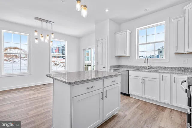 a kitchen with kitchen island granite countertop a sink window and cabinets