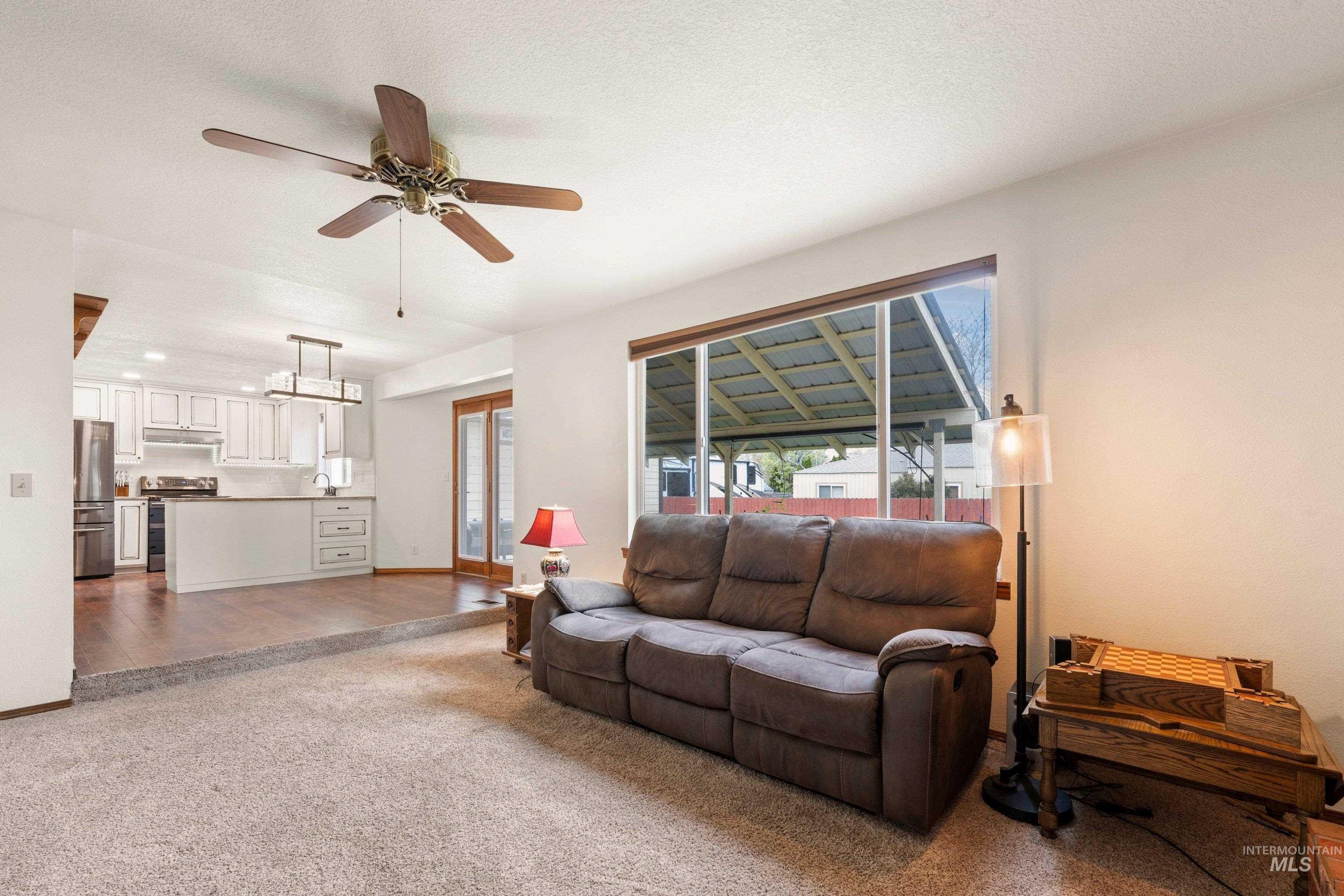 1921 Incline Way Meridian, ID 83646 - Photo 19 of 50 Living area featuring a ceiling fan, large window, and carpeted flooring