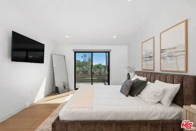 a large bedroom with a bed and glass door