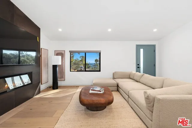 a living room with furniture and a dining table with kitchen view