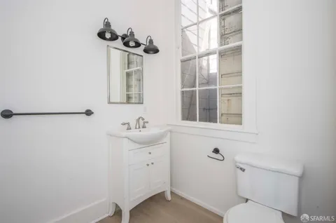 a bathroom with a toilet a sink and mirror