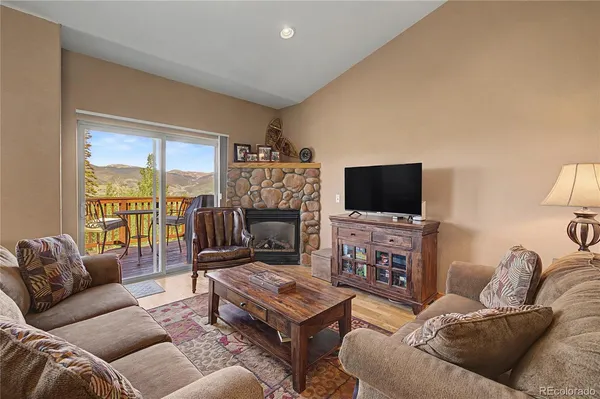 a living room with furniture a flat screen tv and a floor to ceiling window