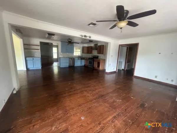 an empty room with a window and a fan