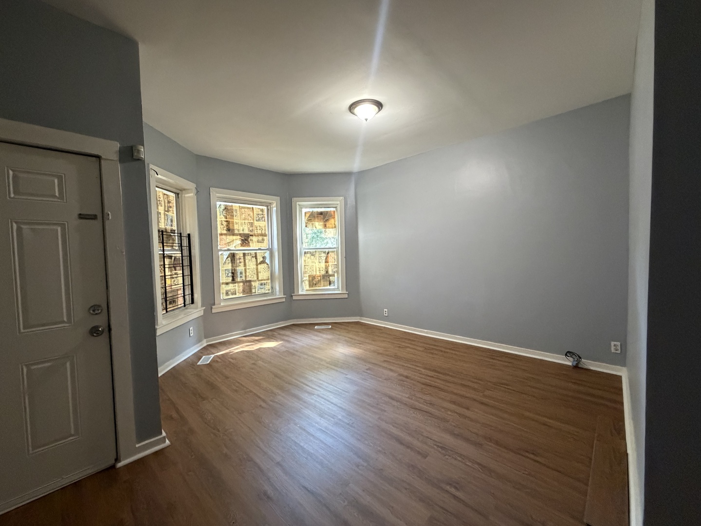 6006 South Marshfield Avenue, Unit 1 Chicago, IL 60636 - Photo 2 of 14 wooden floor in an empty room with a window
