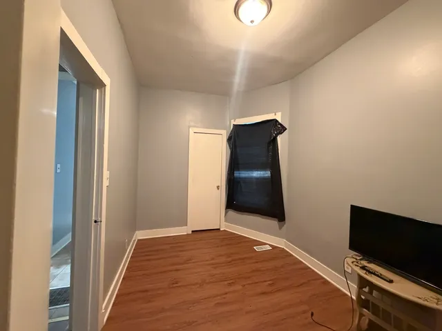 a view of a livingroom with wooden floor and wardrobe