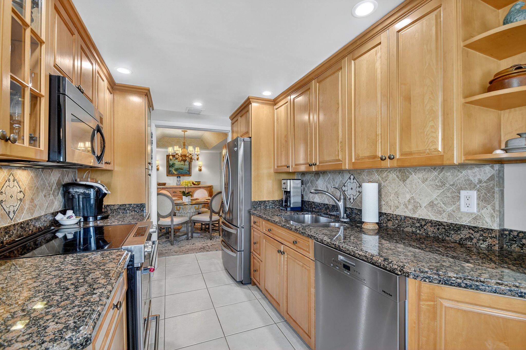 3589 South Ocean Boulevard, Unit 608 South Palm Beach, FL 33480 - Photo 31 of 66 a kitchen with stainless steel appliances granite countertop a stove a sink and a microwave