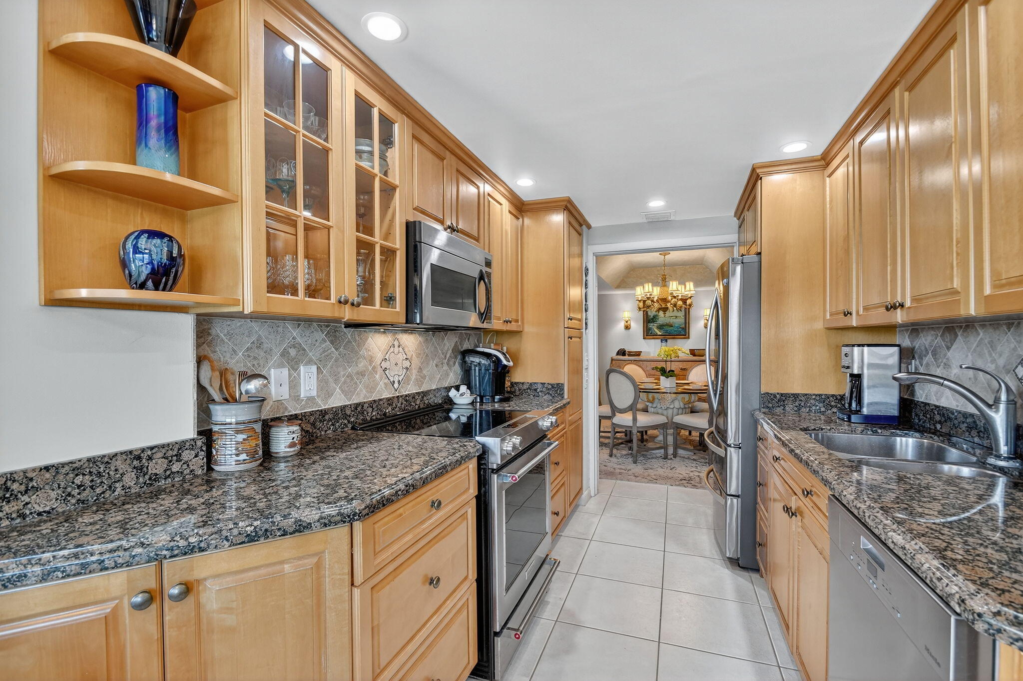 3589 South Ocean Boulevard, Unit 608 South Palm Beach, FL 33480 - Photo 32 of 66 a kitchen with stainless steel appliances granite countertop a sink stove and cabinets