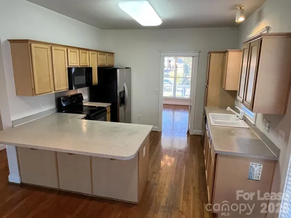 a kitchen with granite countertop a refrigerator stove and sink
