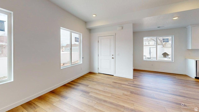 783 Pheasantbrook Drive, Unit 2A Centerville, UT 84014 - Photo 3 of 41 Expansive open-concept space featuring wood-finish flooring, recessed lighting, multiple windows, and a crisp white color palette
