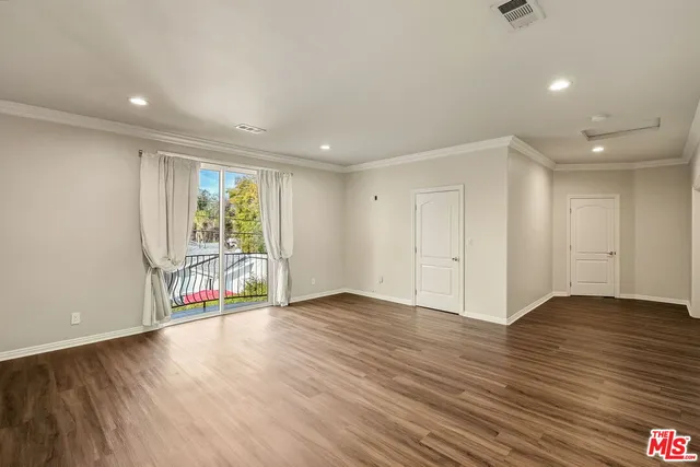a view of an empty room with wooden floor