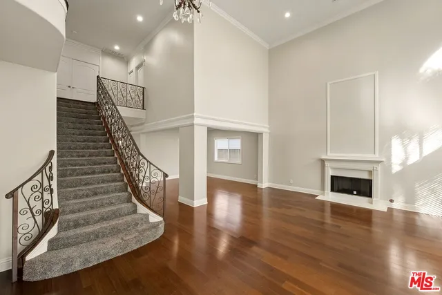 an empty room with wooden floor fireplace and windows