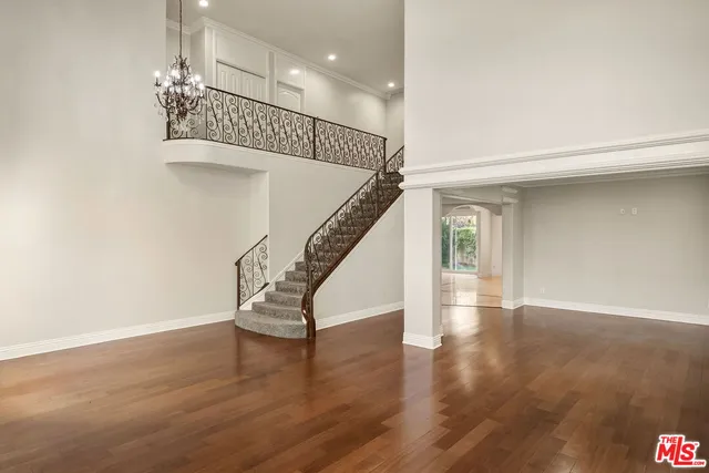 a view of a hallway with wooden floor and a living room