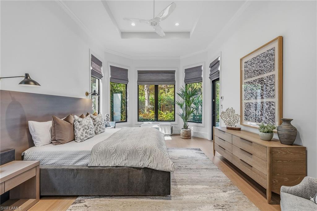 2243 Residence Circle Naples, FL 34105 - Photo 13 of 29 a spacious bedroom with a large bed and a large window