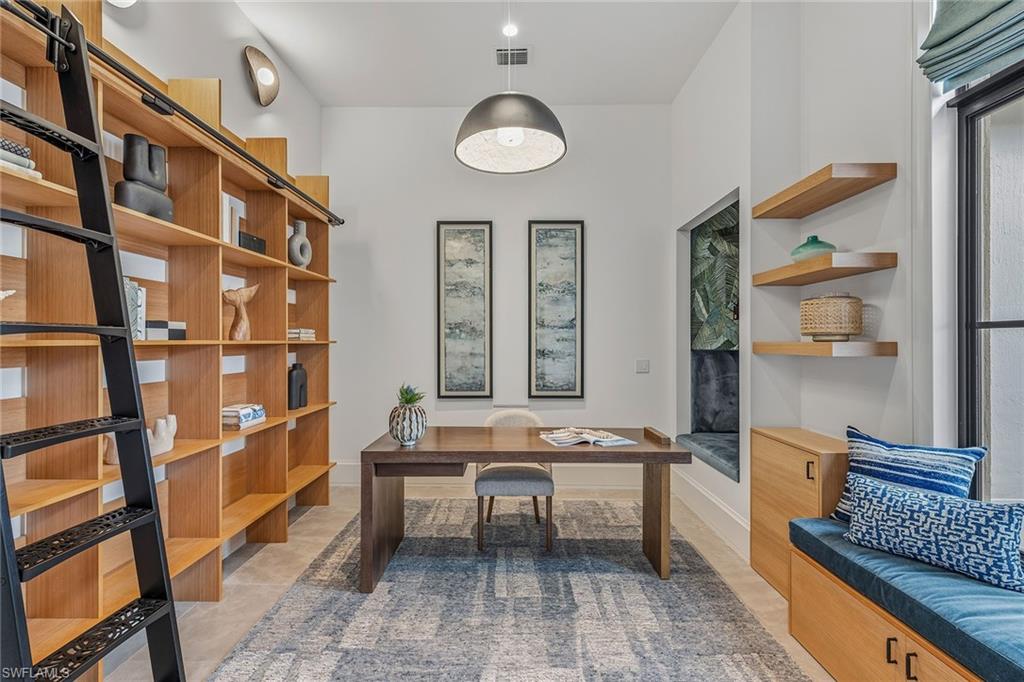 2243 Residence Circle Naples, FL 34105 - Photo 18 of 29 a room with furniture and a book shelf