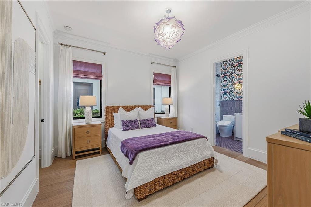 2243 Residence Circle Naples, FL 34105 - Photo 22 of 29 a spacious bedroom with a bed and a chandelier