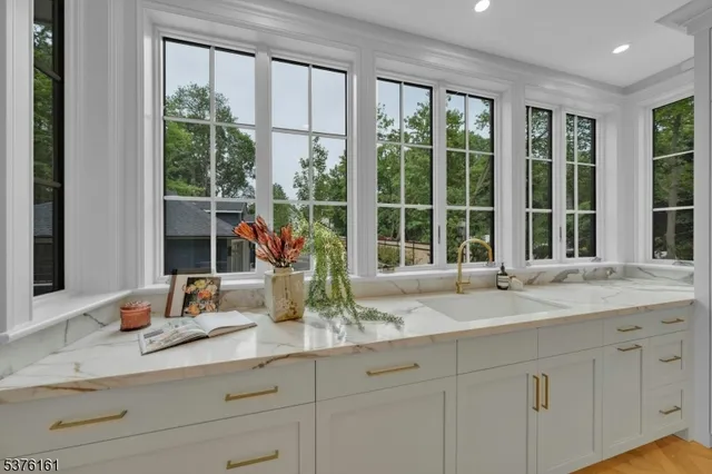 a kitchen with stainless steel appliances granite countertop a stove a refrigerator a oven a sink with a dining table and chairs