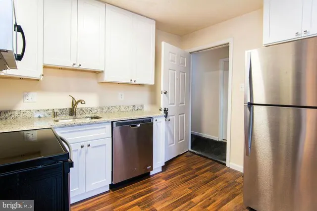 a kitchen with a refrigerator sink and cabinets