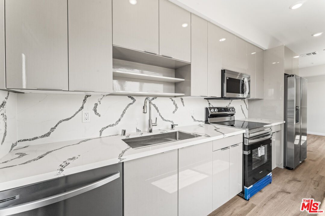 3105 Bellevue Avenue, Unit 405 Los Angeles, CA 90026 - Photo 4 of 26 a kitchen with stainless steel appliances granite countertop a sink a stove and a refrigerator
