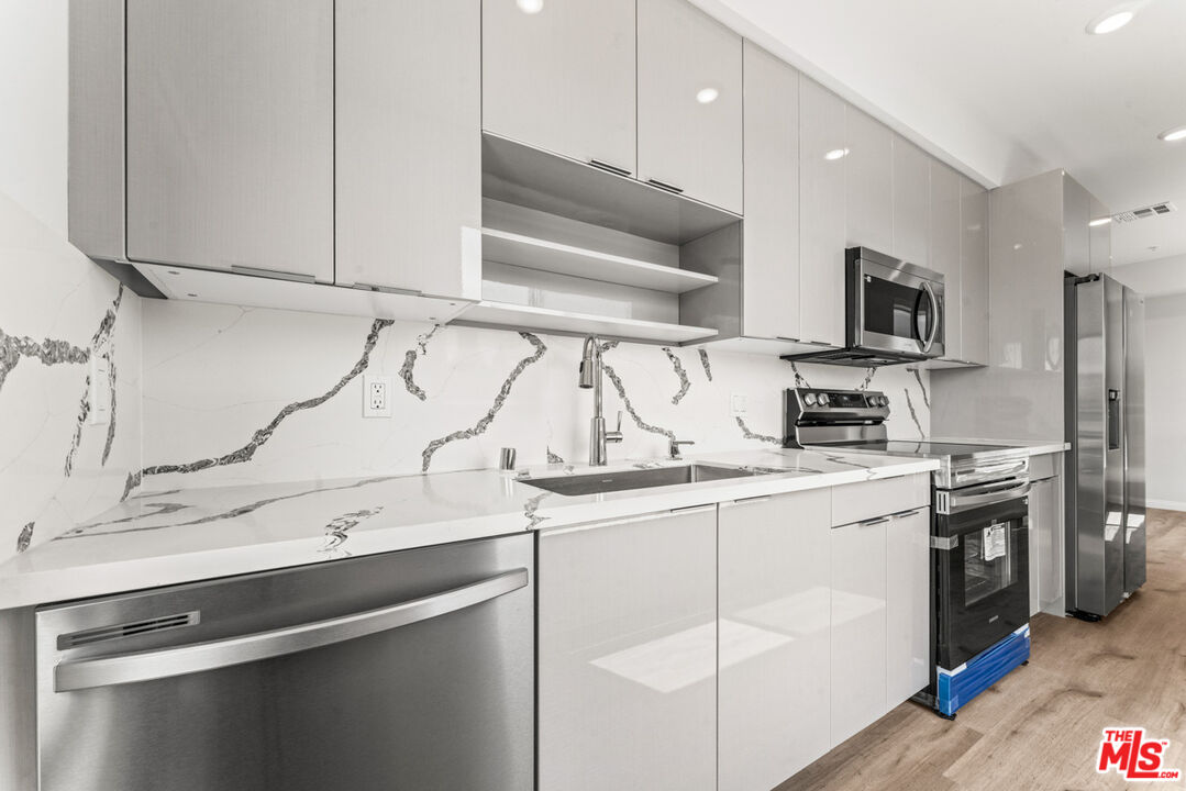 3105 Bellevue Avenue, Unit 405 Los Angeles, CA 90026 - Photo 7 of 26 a kitchen with stainless steel appliances granite countertop a sink a stove and a refrigerator