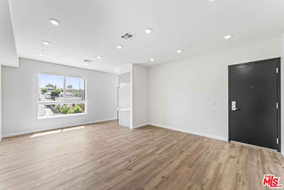 3105 Bellevue Avenue, Unit 405 Los Angeles, CA 90026 - Photo 10 of 26 a view of an empty room with wooden floor and a window