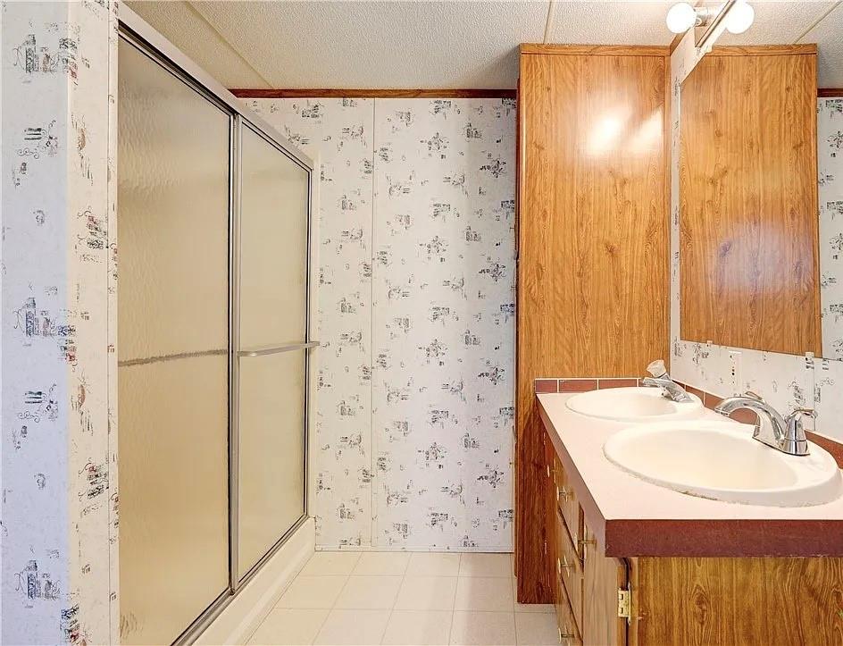 3697 Fm 2808 Road Kempner, TX 76539 - Photo 17 of 18 Double vanity with integrated sinks, chrome faucets, and an expansive mirror