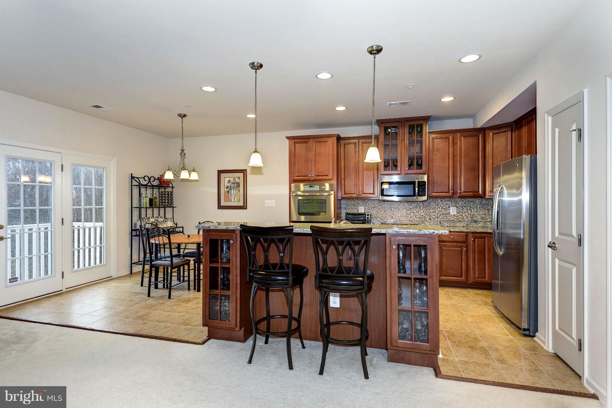a kitchen with kitchen island granite countertop wooden cabinets and a refrigerator