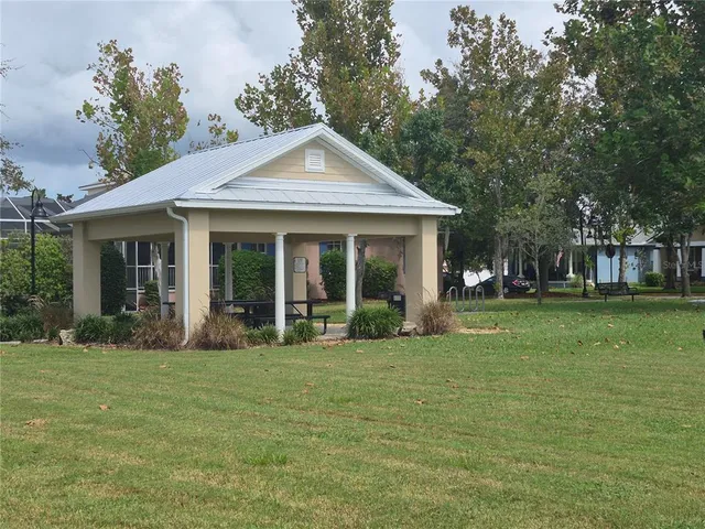 a view of a house with backyard and a tree