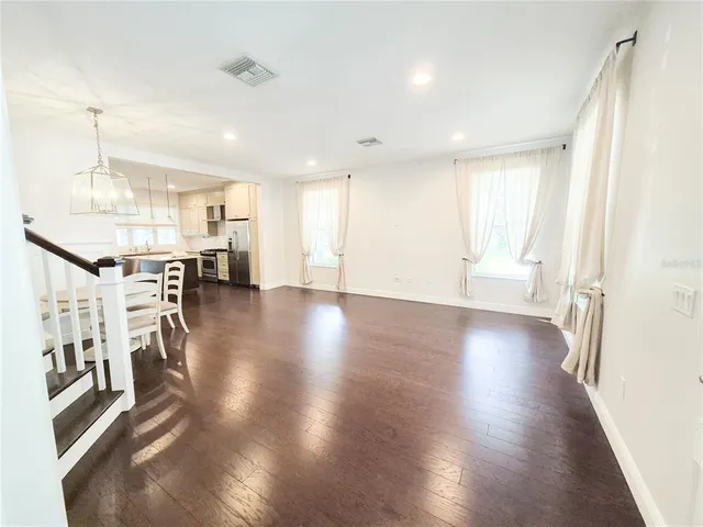 a view of a big room with wooden floor windows and a view
