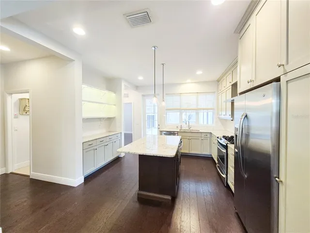 a kitchen with refrigerator cabinets and wooden floor