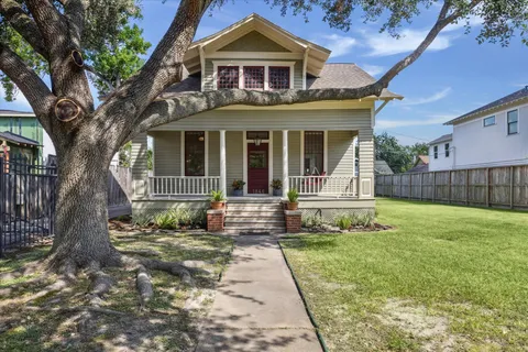 a front view of a house with a garden and trees