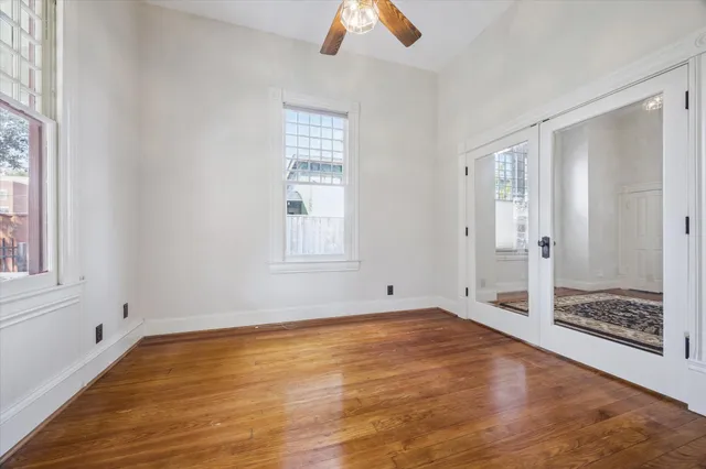 a view of an empty room with window and wooden floor